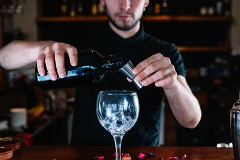Detail of the hands of a bartender using a liquid meter for the making of a Stock Photos