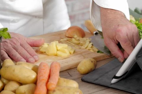 Detail of hands of chef using tablet for cooking Stock Photos