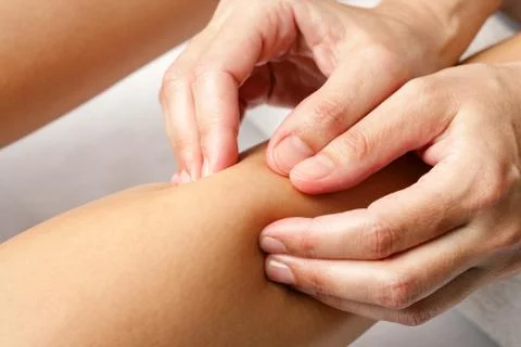 Detail of hands doing osteopathic massage on female calf muscle. Stock Photos