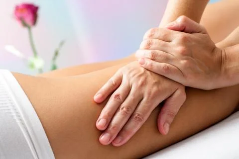 Detail of Hands massaging female hamstrings. Stock Photos