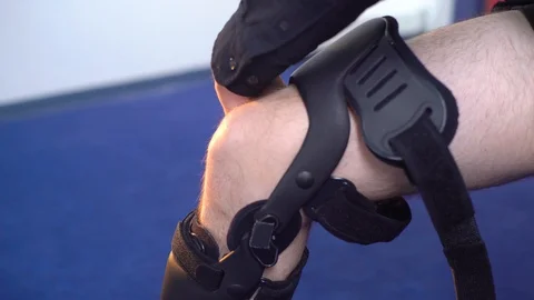 Detail of the lower half of man adjusting a supportive leg brace. Stock Footage 102760601