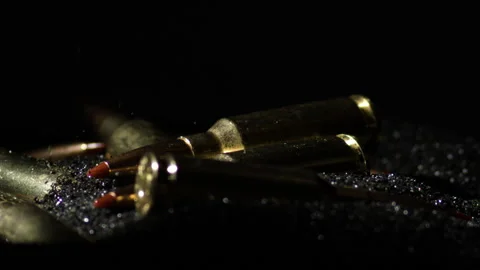 Detail macro shot of bullet falling on pile of gunpowder, tilt down, close Stock Footage 264565460