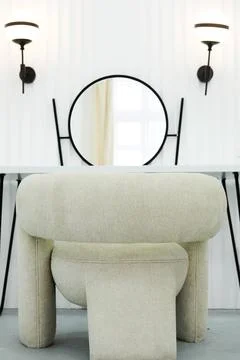 Detail of makeup dressing table with large mirror, lamps and big chair. Whi.. Stock Photos