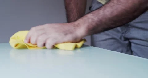 Detail of a man cleaning a table with a sprayer and a cloth. Home cleaning Stock Footage 166533181
