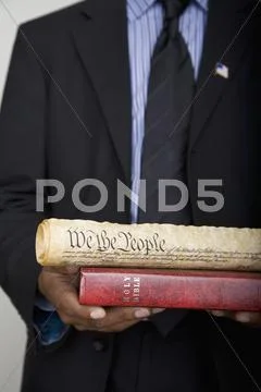 Detail of a man holding a Bible and a scroll of the American Constitution Stock Photos