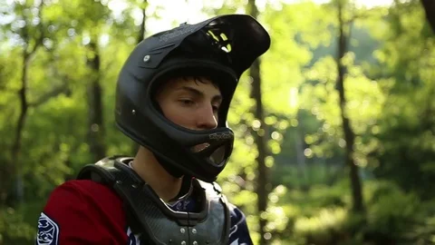 Detail of a man putting his goggles on while wearing a mountain bike helmet, slo Stock Footage