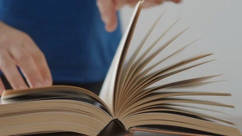Detail of a man's hands turning the sheets of a book Stock Footage 127307315