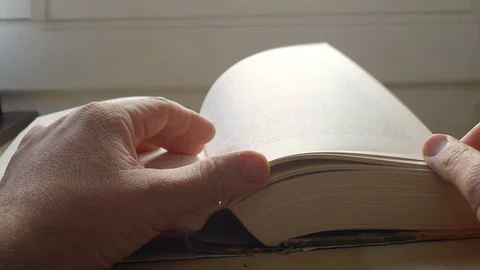 Detail of a man's hands turning the sheets of a book. Stock Footage 129555984