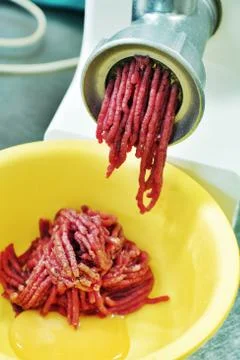 Detail mincing machine in action in kitchen Stock Photos