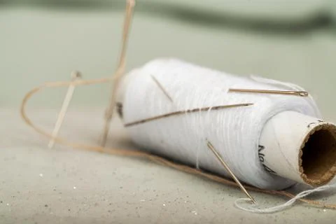 Detail of a needle with thread in the workroom reel of thread Stock Photos