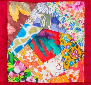 Detail of patchwork quilt framed in red cloth Fotos de archivo