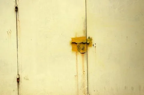 Detail the pattern and texture of the yellow metal door with a l Stock Photos