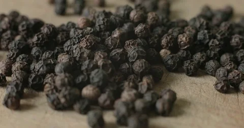 Detail of Peppercorns on a wooden cutting board Stock Footage