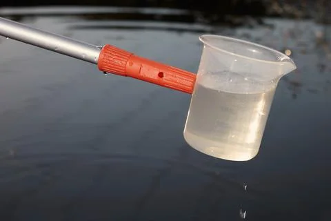Detail of plastic sampling beaker on rod with sample of water Foto stock