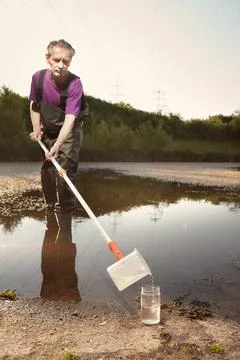 Detail of plastic sampling beaker on rod with sample of water Foto stock