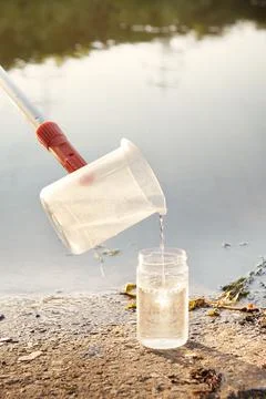 Detail of plastic sampling beaker on rod with sample of water Stock Photos