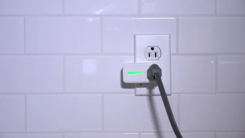 Detail Plugging In Smart Plug into Kitchen Outlet Stock Footage