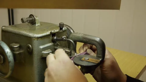 Detail shot of hands using an antique fur sewing machine Stock Footage 274415942