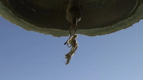 Detail shot of a rope moved by the wind on the clapper of a bell. Stock Footage 135605072