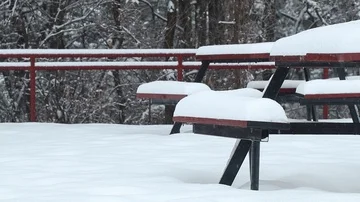 Detail of slow snowfall over bench in the park Stock Footage 85701040