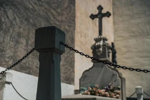 Detail of a stone object with chains surrounding a grave in a cemetery Foto stock