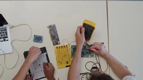 Detail of student hands manipulating electronic devices in technology class Stock Footage 220038786