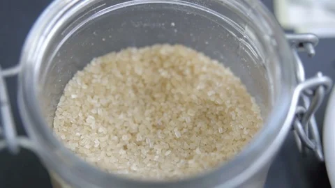 Detail of taking brown sugar with tea spoon from the jar Stock Footage 79529313