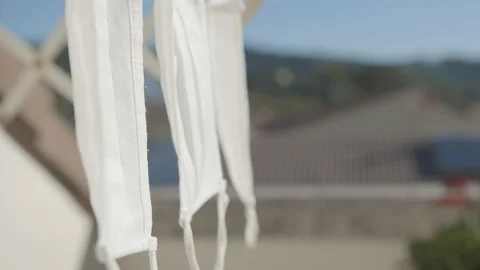 A detail of three masks drying in the sun in slow motion in a terrace Stock Footage 142230254