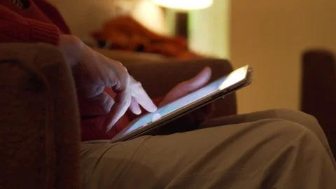 Detail of a Touchscreen Tablet Used at Night by Man, Light Illuminating Fingers Stock Footage