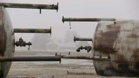 Detail of Two Large Water containers junked in farm field winter fog Stock Footage 89945131