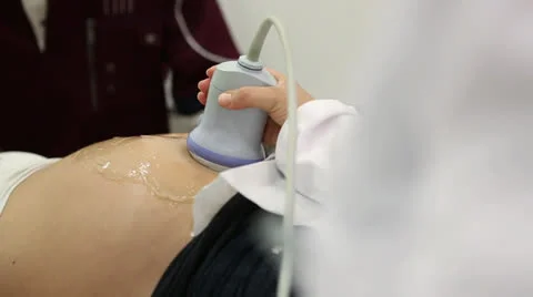 Detail of ultrasound probe moving over belly of pregnant woman Vídeos de archivo 24695953