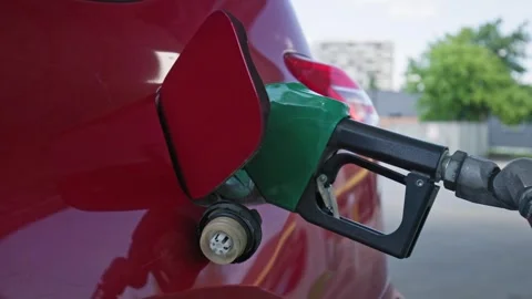 Detail view of gas nozzle inserted into red car receiver Stock Footage 309662435