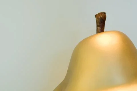 Detail view of a interior design object: a golden shiny apple with wooden stem Stock Photos
