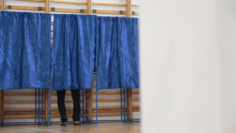 Detail of a voter inside the blue voting booth during election day Stock Footage 320962709