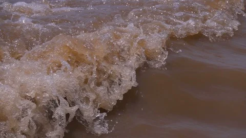 Detail of wave crest in slow motion in muddy dirty water Stock Footage 87703365