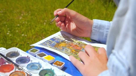 Detail of a woman painter/artist painting a picture using brush and watercolor Stock Footage
