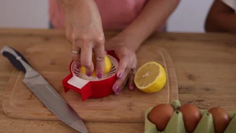 Detail of woman squeezing lemon while making Christmas cookies with daughter Stock Footage 346681587