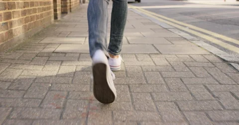 Detail of woman's feet walking through city Stock Footage