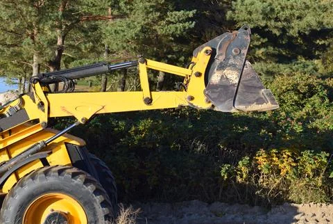 Detail of Yellow Backhoe Loader Working on Sand in a Public Park Stock Photos