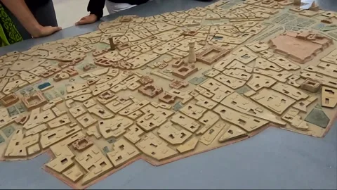 Detailed 3D scale model of Bukhara old town with a tour guide gesturing Stock Footage 335774774