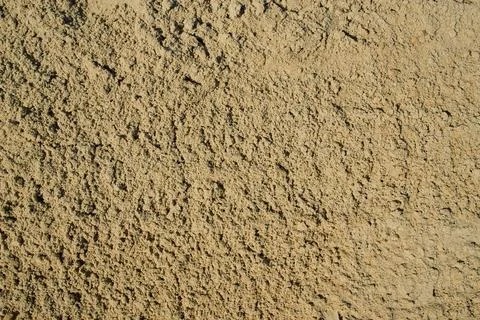 Detailed abstract background of coarse construction sand grains under bright  Stock Photos