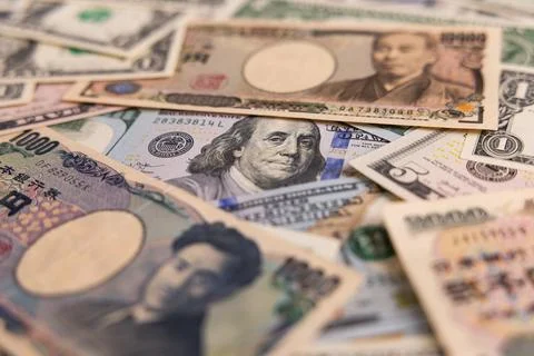 Detailed backdrop of mixed US dollar and Japanese yen banknotes Stock Photos