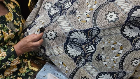 Detailed Close-Up of Artisan Creating Batik Pattern on Fabric Stock Footage 344087601
