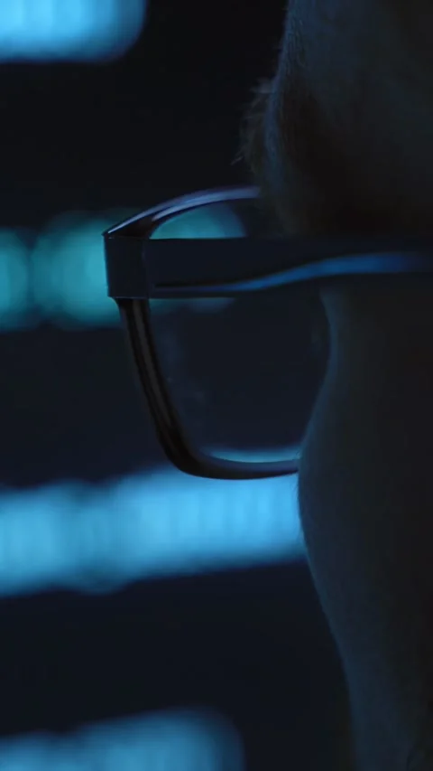 Detailed close up, coder in glasses looking at screen with code Stock Footage 345446261