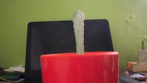 Detailed Close-up of a Decorative Spoon Resting in a Vibrant Red Cup Agains.. Stock Footage 325234815