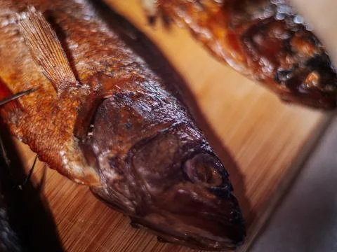 A detailed close-up of dried roach with crispy brown skin lying. Stock Photos