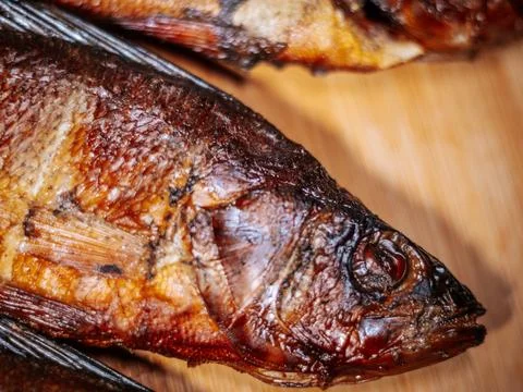 A detailed close-up of dried roach with crispy brown skin lying. Stock Photos