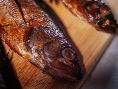A detailed close-up of dried roach with crispy brown skin lying. Stock Photos