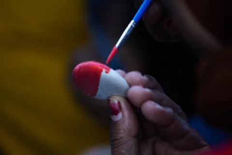 Detailed Close Up of Hand Using Fine Brush to Paint Red Layer on Small Oval.. Stock Photos