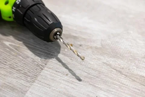 This is a detailed close up image of a drill bit placed on a wooden surface Stock Photos